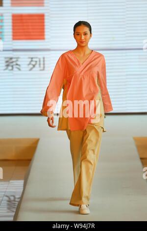 A woman displays a new hospital uniform for patients during a fashion show in Beijing, China, 1 April 2013.   A special fashion show was held at a hos Stock Photo