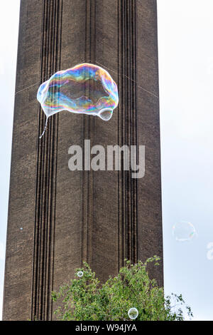 A giant bubble rises into the air on the south bank of the River Thames, the Tate Modern art gallery in the background, Bankside, London, UK Stock Photo