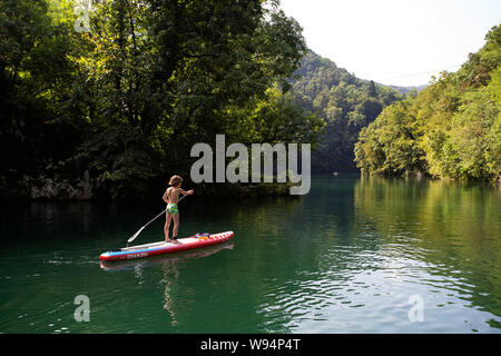 Young boy having fun on stand up paddle  on the Soca river at Most na Soci, Slovenia Stock Photo