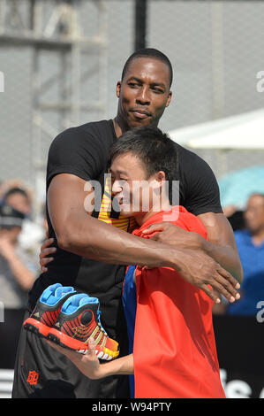 NBA star Dwight Howard of the Houston Rockets basketball team left hugs a Chinese fan during a promotional event for Nike in Chengdu southwest Chin Stock Photo Alamy