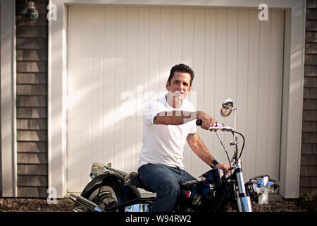 Man sitting on his Harley Davidson Stock Photo