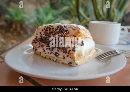 Typical Italian and Sicilian dessert – role pasta di bigne with ricotta and chocolate drops. Closeup of italian dessert on the table in the bar with t Stock Photo