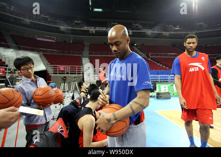 Stephon Marbury of Beijing Ducks signs on basketballs for fans during a training session in Beijing, China, 27 March 2012.   Beijing Ducks is preparin Stock Photo