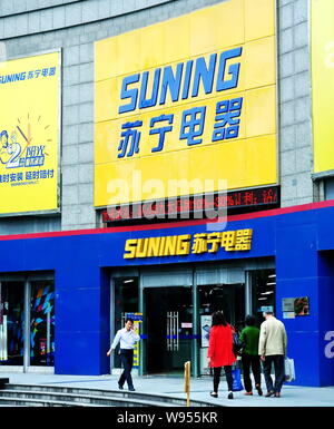 --FILE--Pedestrians walk past a Suning home appliances store in Shanghai, China, 9 May 2012.   To enhance its capital capacity and support the constru Stock Photo