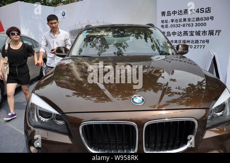 --FILE--Visitors try out a BMW X1 during an auto show in Qingdao city, east Chinas Shandong province, 8 September 2012.   Strong sales of its luxury c Stock Photo