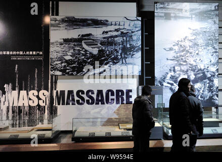 Visitors look at old file photos and other exhibitions at the Memorial Hall of the Victims in Nanjing Massacre by Japanese Invaders in Nanjing city, e Stock Photo