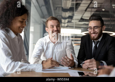 Smiling diverse colleagues having fun at business briefing in office Stock Photo