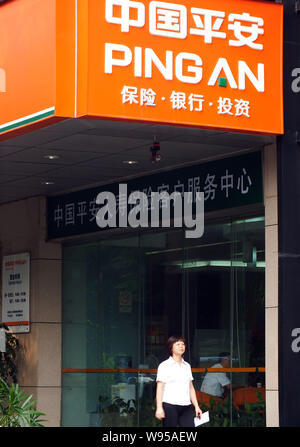 --File--A pedestrian walks past a branch of Ping An Insurance in Guangzhou city, south Chinas Guangdong province, 29 August 2012.   Ma Mingzhe, chairm Stock Photo