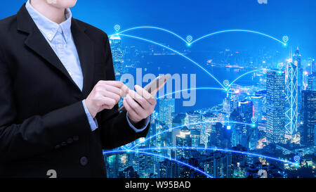 Asian business woman use smartphone technology in Smart city with communication network and big data system. Stock Photo