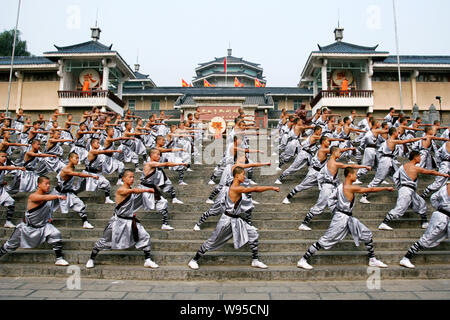 --FILE--Chinese monks perform in front of the martial arts gymnasium at the Shaolin Temple scenic spot in Dengfeng city, central Chinas Henan province Stock Photo