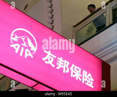 --FILE--A visitor looks on above a signboard of AIA during an expo in Shanghai, China, 18 November 2011.   Insurance giant American International Grou Stock Photo