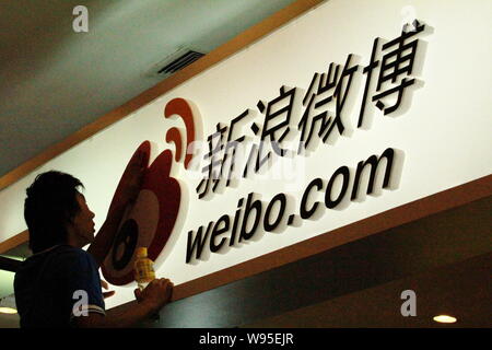 --FILE--A Chinese worker puts final touches on the stand of weibo.com, the Twitter-like online microblogging service of Sina, during the China Interne Stock Photo