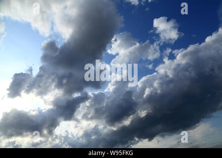 Cloudy sky, white, grey, black, clouds, blue skies, meteorology, weather, threatening rain Stock Photo
