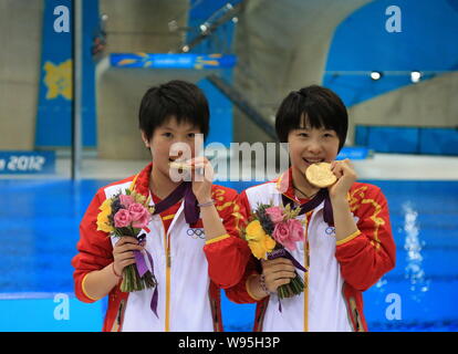 Gold medalists Chen Ruolin, left, and Wang Hao of China bite their medals at the award ceremony after winning the womens diving synchronised 10m platf Stock Photo