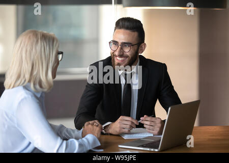 Smiling young employee and mature businesswoman working together Stock Photo