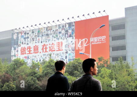 --File--Chinese men walk past a huge billboard of Alibaba at the headquarters of Alibaba Group in Hangzhou city, east Chinas Zhejiang province, 16 Sep Stock Photo
