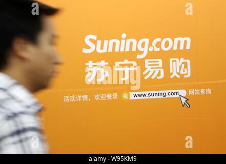 --File--A pedestrian walks past an advertisement for Suning Yigou in Beijing, China, 22 June 2012.   Suning Yigou, the online arm of the Chinas larges Stock Photo