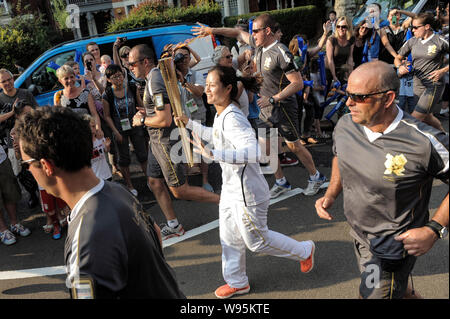 Chinese tennis player Li Na holding the Olympic torch jogs during the Torch Relay of the London 2012 Olympic Games in Haringey, London, UK, 25 July 20 Stock Photo