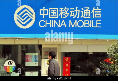 --File--A pedestrian walks past a branch of China Mobile in Shanghai, China, 16 January 2010.    China Mobile Communications Corp, the parent company Stock Photo