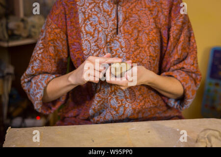 Woman potter making ceramic souvenir penny whistle in pottery workshop Stock Photo