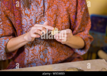 Woman potter making ceramic souvenir penny whistle in pottery workshop Stock Photo