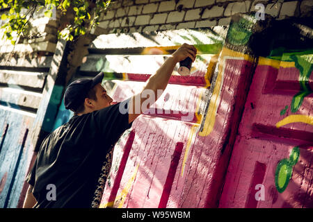 Kharkiv, UKRAINE July 30, 2019: A fellow draws bright street graffiti on an opening of youth park day. Stock Photo