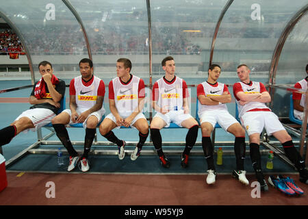 Dimitar Berbatov, left, Javier Hernandez, second right, and other players of Manchester United rest in their friendly soccer match against Shanghai Sh Stock Photo