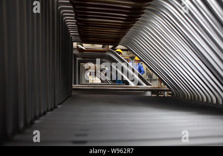 --FILE--Chinese factory workers transport auto parts at the auto plant of JMC (Jiangling Motors Co., Ltd.) in Nanchang city, east Chinas Jiangxi provi Stock Photo