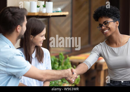Happy couple handshake female specialist at meeting Stock Photo