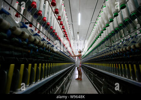 --FILE--A female Chinese worker handles the production of yarn to be exported to southeast Asia at a textile factory in Huaibei city, east Chinas Anhu Stock Photo