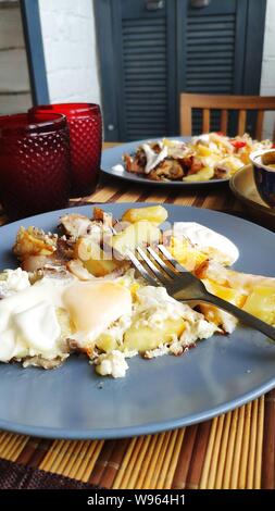 A side view breakfast for two, baked fish and potatoes with pickles, English breakfast, healthy eating concept, selective focus Stock Photo