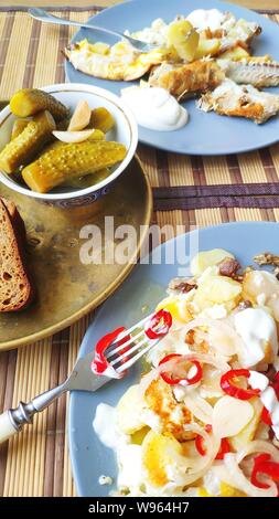 A side view breakfast for two, baked fish and potatoes with pickles, English breakfast, healthy eating concept, selective focus Stock Photo