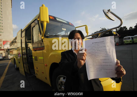 A school bus driver shows his safety undertaking in Chongming county, Shanghai, China, 2 February 2012.    School buses have prioritized right of way Stock Photo