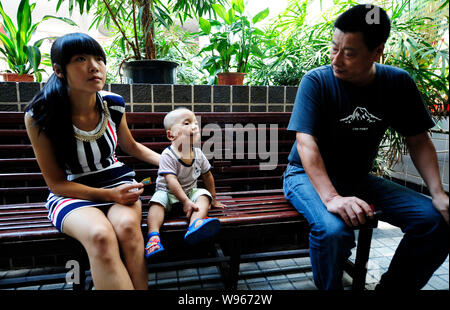 Junjun, who was born with a congenital facial cleft palate, is accompanied by his parents at a hospital in Chongqing, China, 30 July 2012.   Junjun is Stock Photo