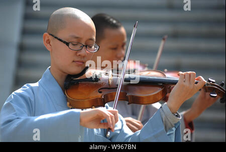 Chinese Buddhist nuns of Guangxuan Art Troupe practice playing violin during a training session at Tiantai Temple on Tiantai Mountain in HongAn county Stock Photo