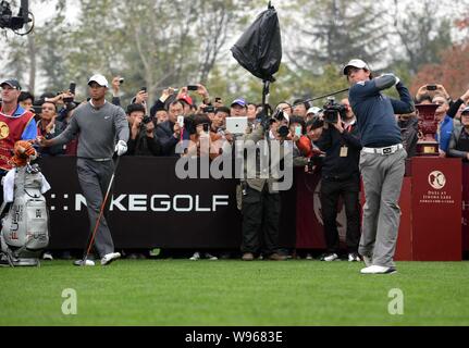 Rory McIlroy of Northern Ireland, right, tees off as Tiger Woods of the United Stated, left, watches during the Duel at Jinsha Lake golf exhibition ma Stock Photo