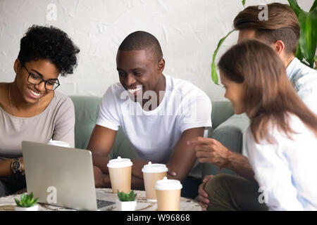 Happy diverse friends laugh hanging out in cafe Stock Photo