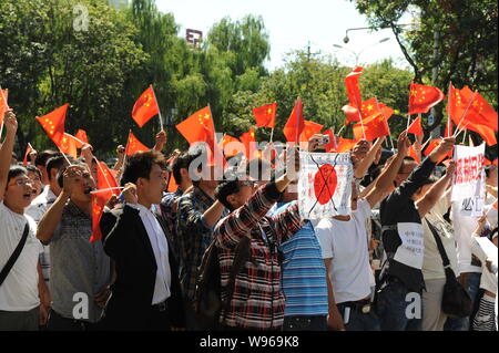 Chinese protestors wave Chinese national flags, hold up banners and shout slogans during an anti-Japan protest outside the Embassy of Japan in China i Stock Photo