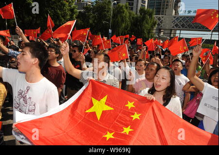 Chinese protestors wave Chinese national flags and shout slogans during an anti-Japan protest outside the Embassy of Japan in China in Beijing, China, Stock Photo