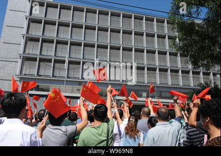 Chinese protestors wave Chinese national flags during an anti-Japan protest outside the Embassy of Japan in China in Beijing, China, 14 September 2012 Stock Photo