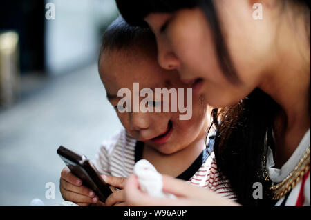 Junjun, who was born with a congenital facial cleft palate, is seen playing games at a hospital in Chongqing, China, 30 July 2012.   Junjun is a 1-yea Stock Photo