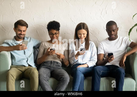 Multiracial young people using smartphones waiting in queue Stock Photo