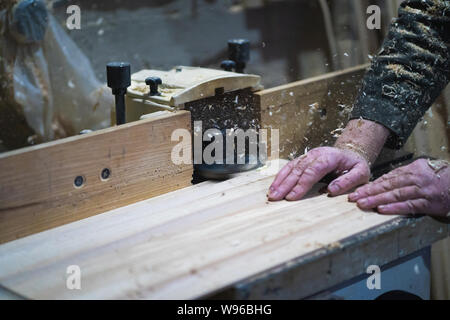 A man is working with wood on milling machine Stock Photo
