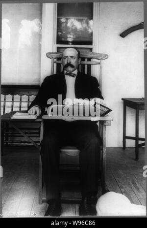 Alton Brooks Parker, 1852-1926, full length portrait, seated, facing slightly left in classroom desk chair reading Harper's Magazine Stock Photo
