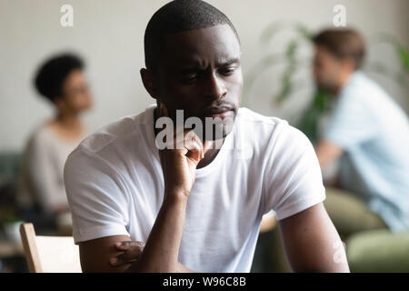 Unhappy black male loner feel hurt sitting alone Stock Photo