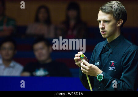 Judd Trump of England chalks his cue as he competes against Mark Allen of Northern Ireland during the second round of the World Snooker Shanghai Maste Stock Photo