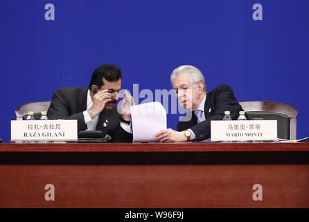 Italian Prime Minister Mario Monti (R) shows a memo to Pakistan Prime Minister Syed Yousuf Raza Gilani during the opening ceremony of the Boao Forum f Stock Photo