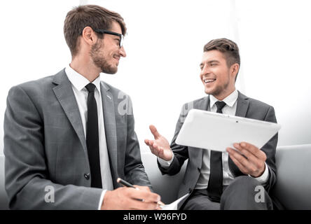 two men chatting while sitting in the office Stock Photo