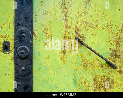 Closeup of an old yellow steel door with rusty handle Stock Photo