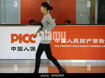 A customer walks past a counter of PICC Property and Casualty Co., Ltd. at a branch in Shanghai, China, 22 November 2012.   American International Gro Stock Photo